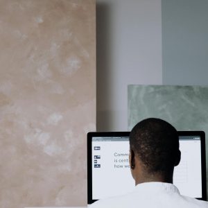 Back view of a man working at a computer in a modern office setting. Ideal for business themes.